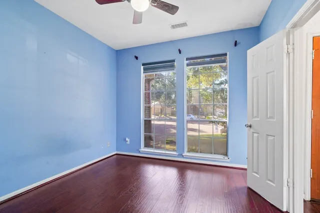 a view of room with window ceiling fan and hardwood floor