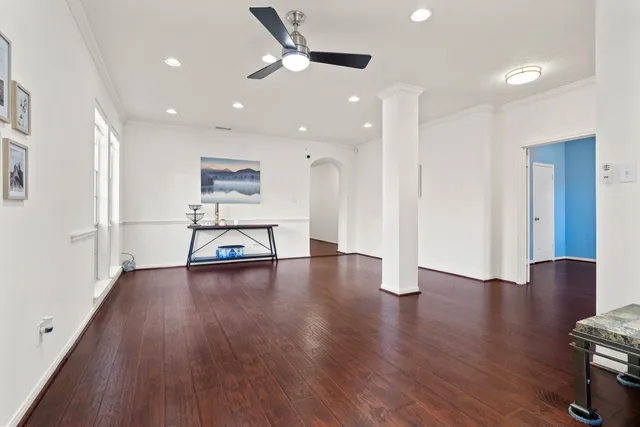 a view of a big room with wooden floor and windows