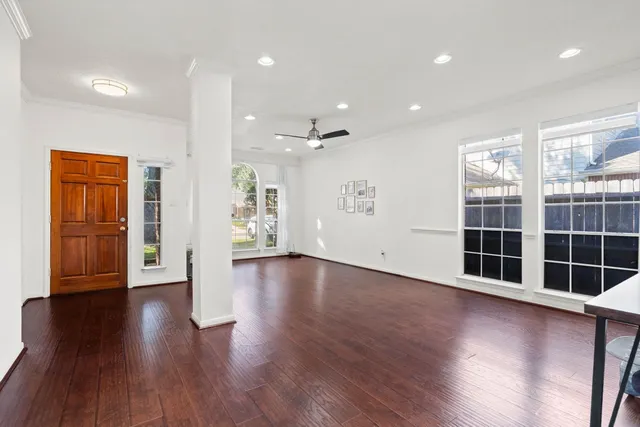an empty room with wooden floor and windows