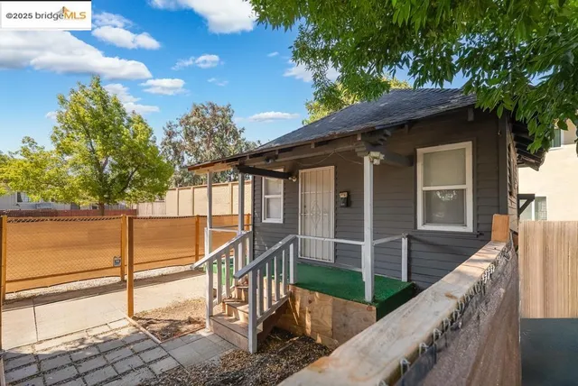 a view of a house with large windows and a small yard