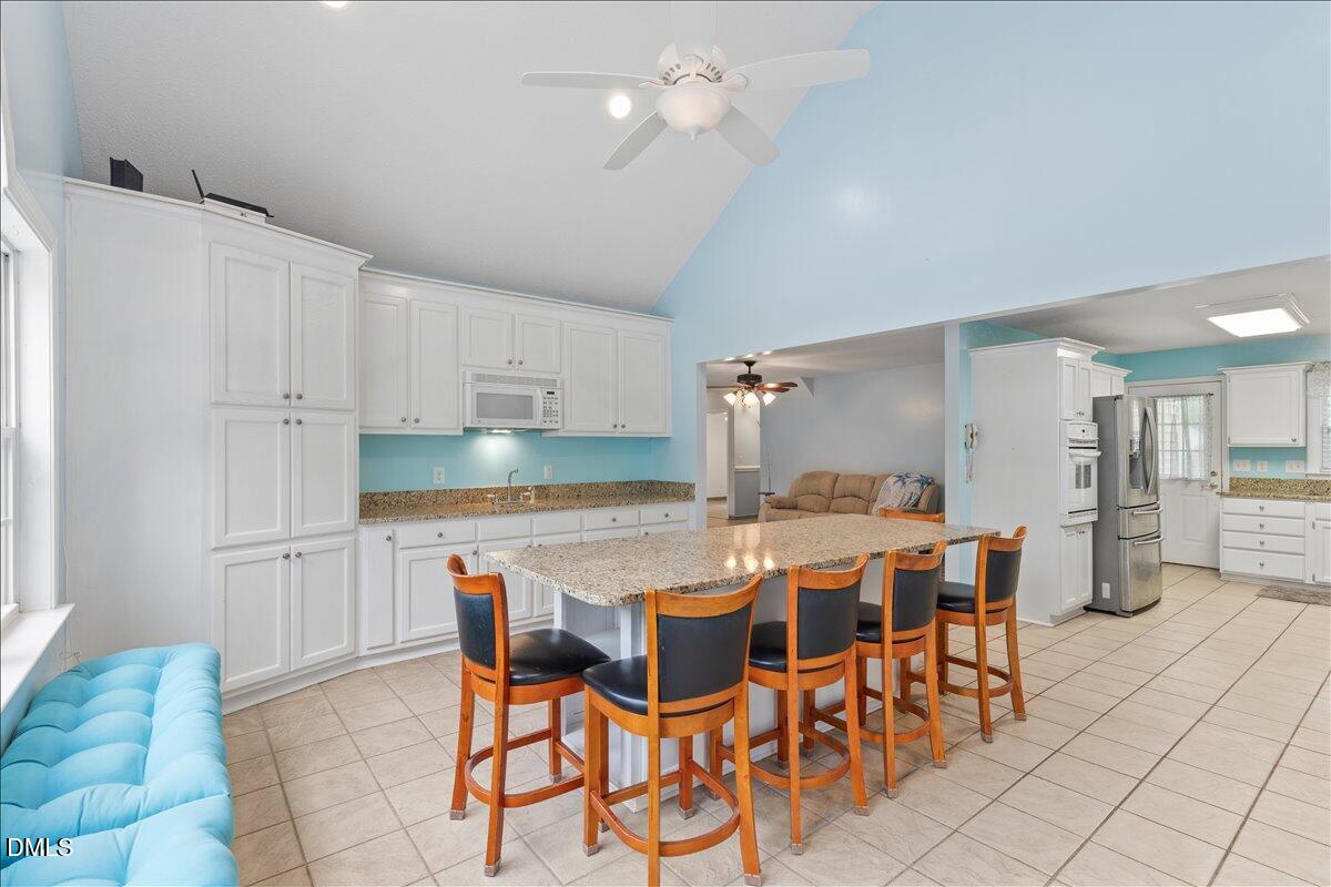 4317 South Mountain Drive Raleigh, NC 27603 - Photo 12 of 57 a dining hall with stainless steel appliances a table and chairs