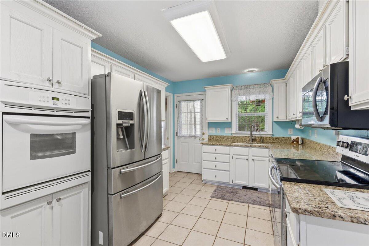 4317 South Mountain Drive Raleigh, NC 27603 - Photo 13 of 57 a kitchen with stainless steel appliances granite countertop a refrigerator sink stove and microwave