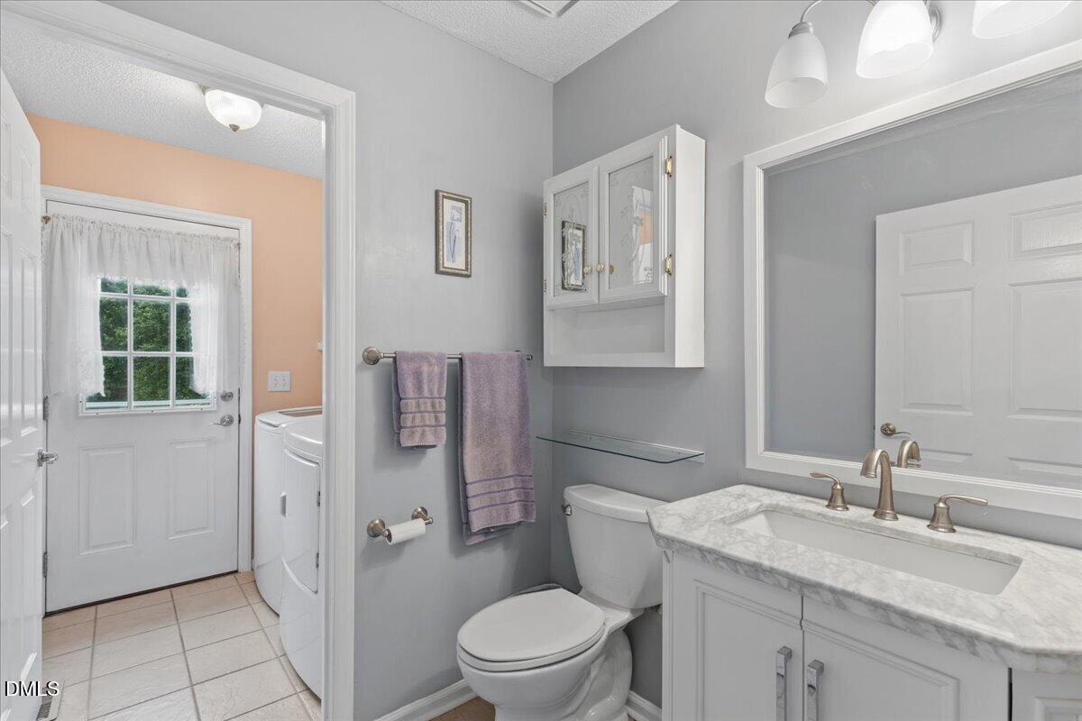 4317 South Mountain Drive Raleigh, NC 27603 - Photo 16 of 57 a bathroom with a granite countertop sink toilet and shower