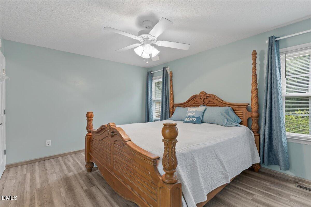 4317 South Mountain Drive Raleigh, NC 27603 - Photo 21 of 57 a bedroom with a bed and a chandelier