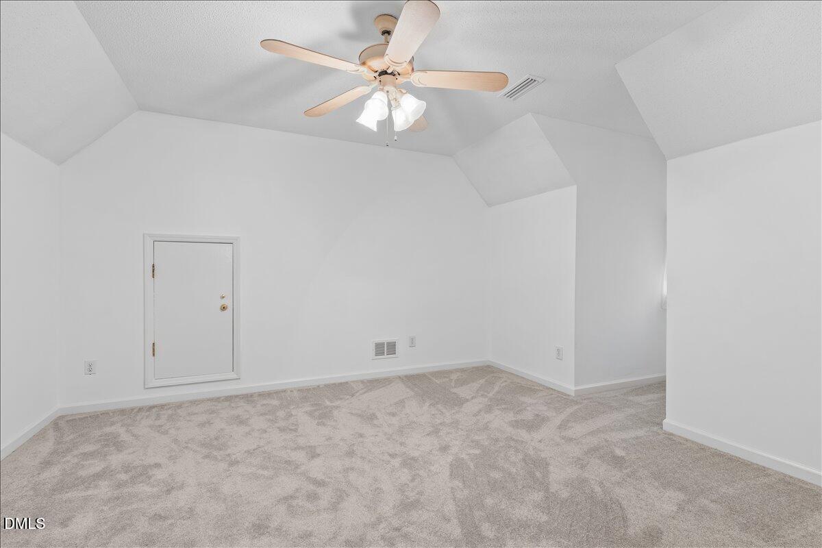 4317 South Mountain Drive Raleigh, NC 27603 - Photo 26 of 57 an empty room with a chandelier fan and windows
