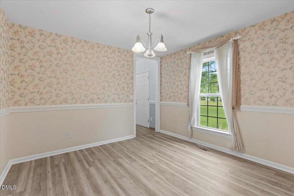 4317 South Mountain Drive Raleigh, NC 27603 - Photo 6 of 57 wooden floor in an empty room with a window