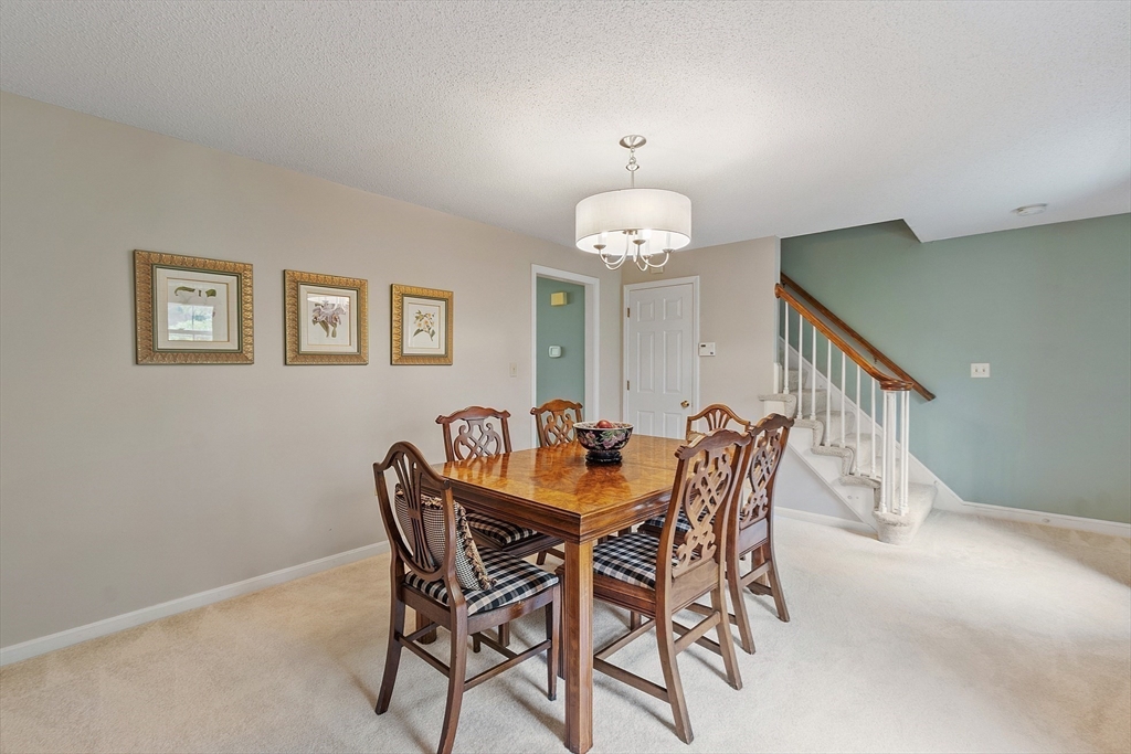 187 Turnpike Road, Unit 187 Chelmsford, MA 01824 - Photo 15 of 42 a view of a dining room with furniture and chandelier