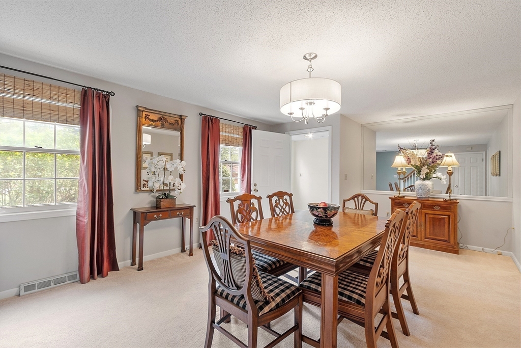 187 Turnpike Road, Unit 187 Chelmsford, MA 01824 - Photo 16 of 42 a view of a dining room with furniture and chandelier