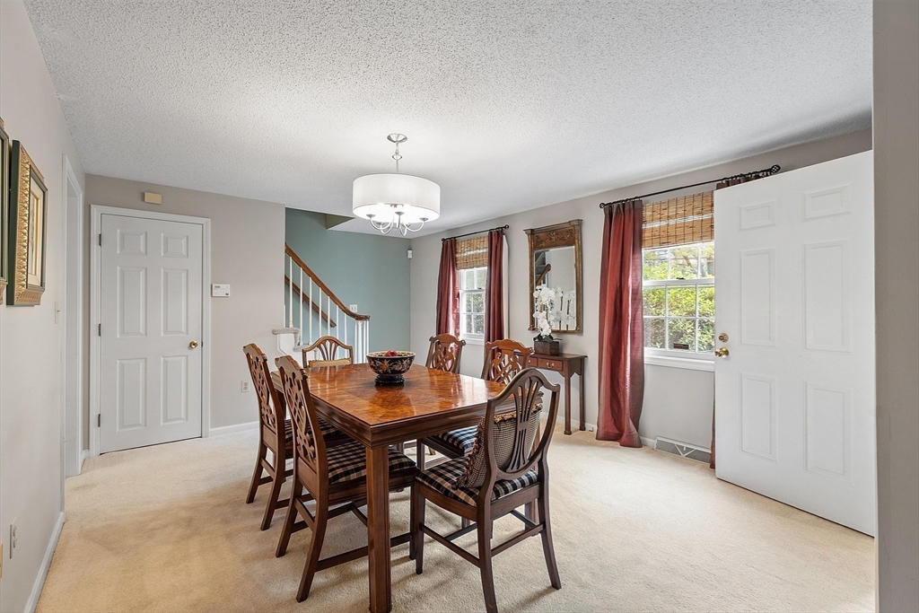 187 Turnpike Road, Unit 187 Chelmsford, MA 01824 - Photo 17 of 42 a view of a dining room with furniture and chandelier