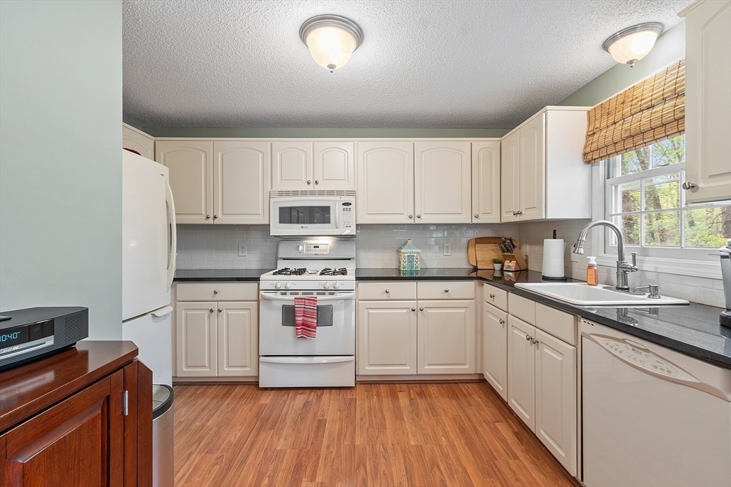 187 Turnpike Road, Unit 187 Chelmsford, MA 01824 - Photo 2 of 42 a kitchen with stainless steel appliances granite countertop a stove a sink dishwasher and a refrigerator