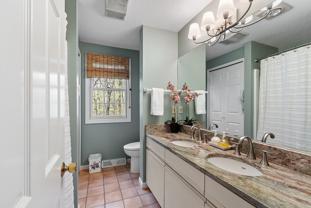 187 Turnpike Road, Unit 187 Chelmsford, MA 01824 - Photo 27 of 42 a bathroom with a double vanity sink mirror and toilet