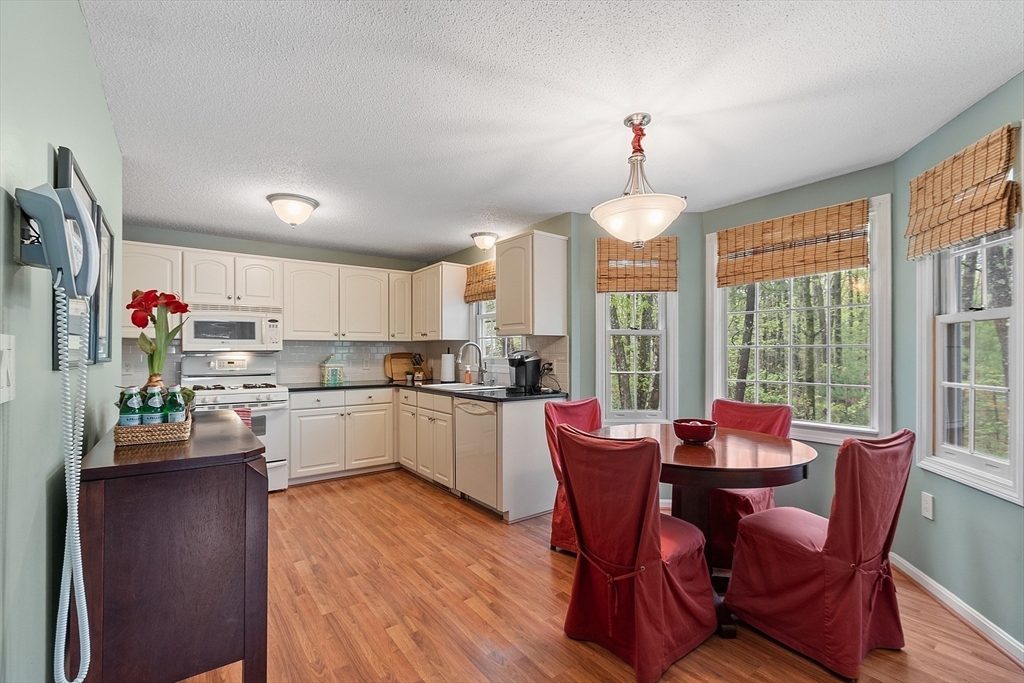 187 Turnpike Road, Unit 187 Chelmsford, MA 01824 - Photo 6 of 42 a kitchen that has a dining table chairs and stainless steel appliances