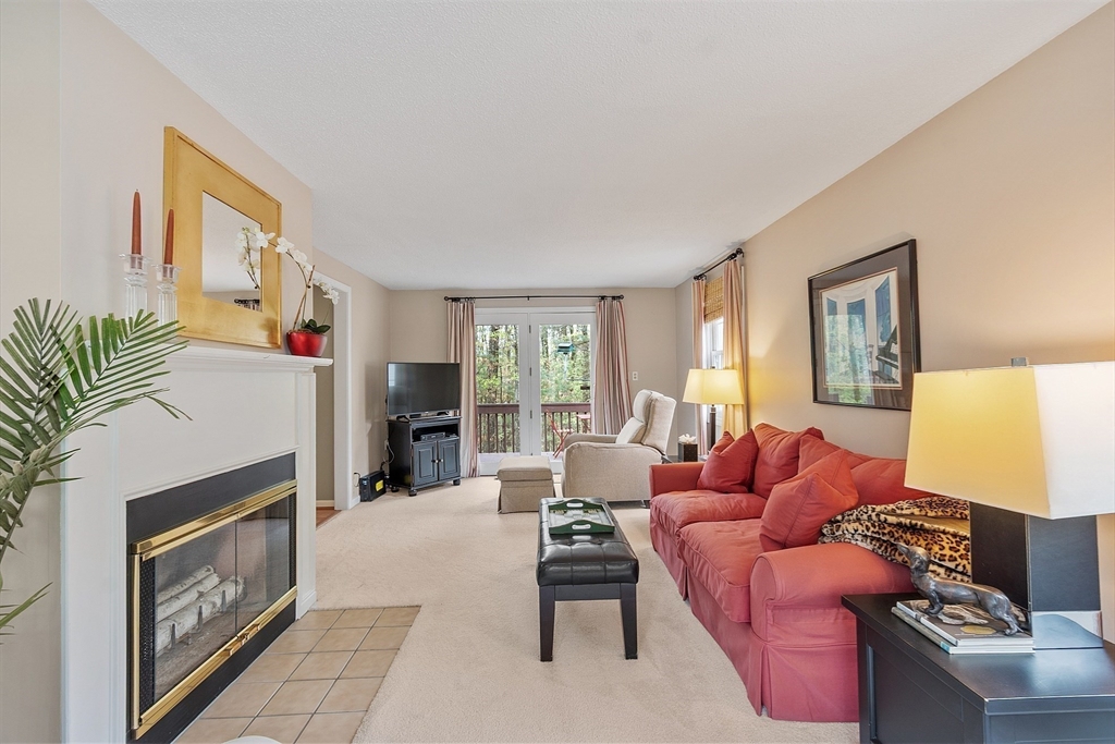 187 Turnpike Road, Unit 187 Chelmsford, MA 01824 - Photo 8 of 42 a living room with furniture and a fireplace