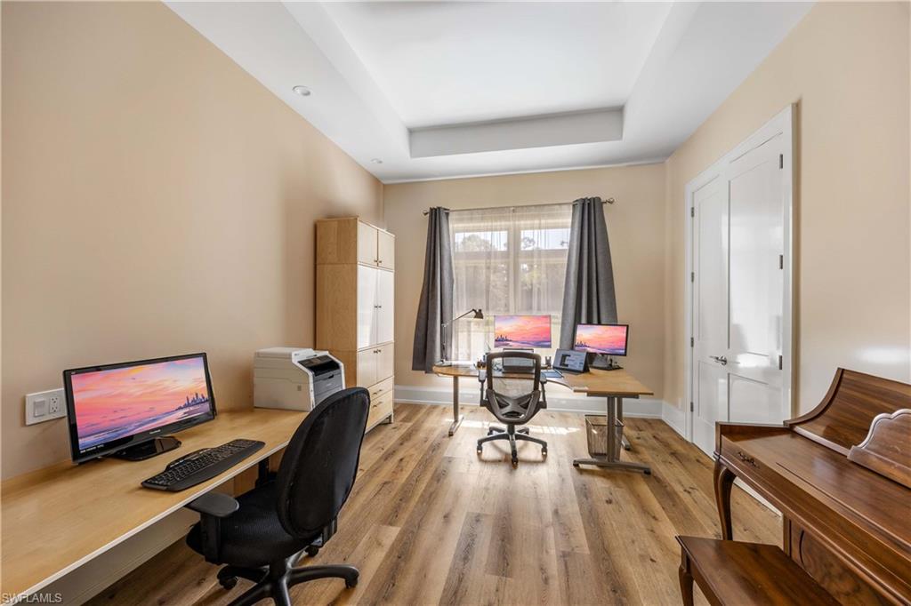 4885 Tamarind Ridge Drive Naples, FL 34119 - Photo 15 of 39 a workspace with furniture and a wooden floor