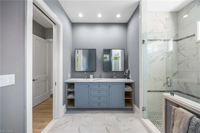 a bathroom with a granite countertop sink a large mirror and a bathtub