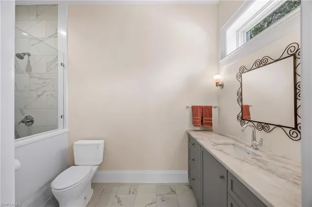 a bathroom with a granite countertop sink toilet and shower