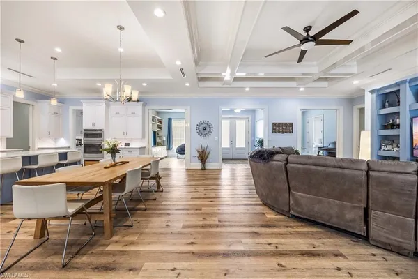 a living room with furniture kitchen view and a chandelier