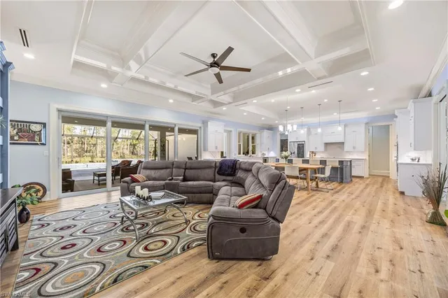a living room with furniture hard wood floor and a ceiling fan