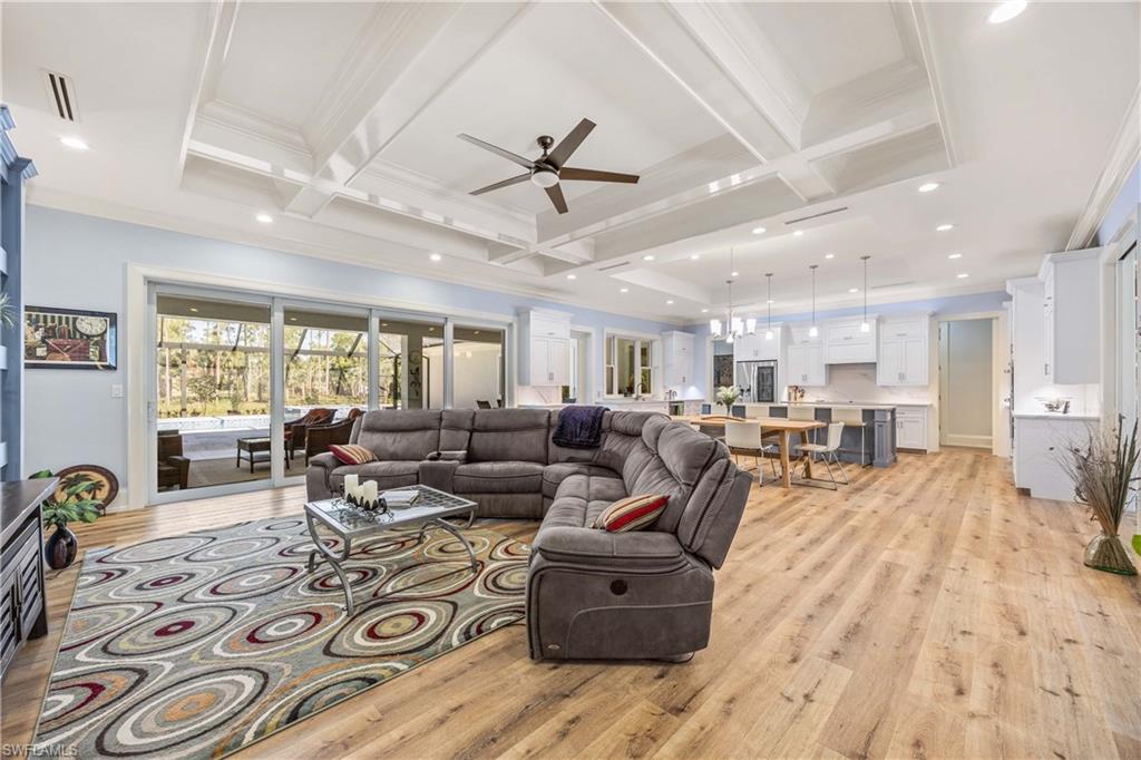 4885 Tamarind Ridge Drive Naples, FL 34119 - Photo 5 of 39 a living room with furniture hard wood floor and a ceiling fan