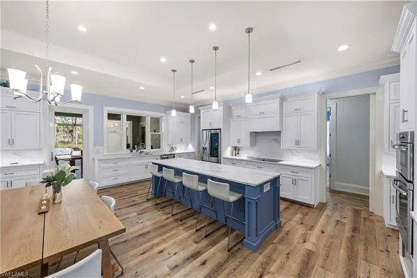 a large kitchen with lots of counter space a sink appliances and cabinets