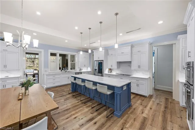 a large kitchen with lots of counter space a sink appliances and cabinets