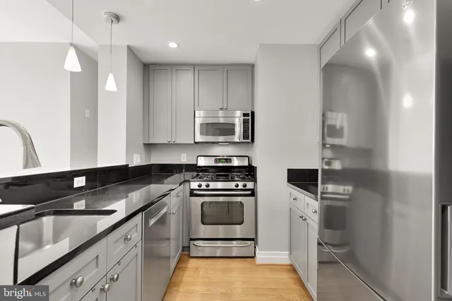 a kitchen with stainless steel appliances granite countertop a sink and a stove
