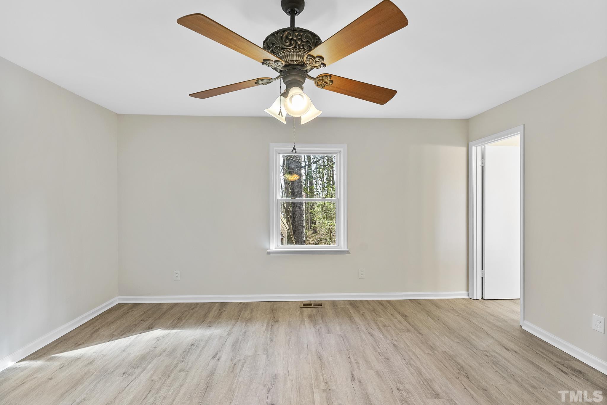 2125 Strebor Street Durham, NC 27705 - Photo 24 of 38 an empty room with wooden floor chandelier fan and windows