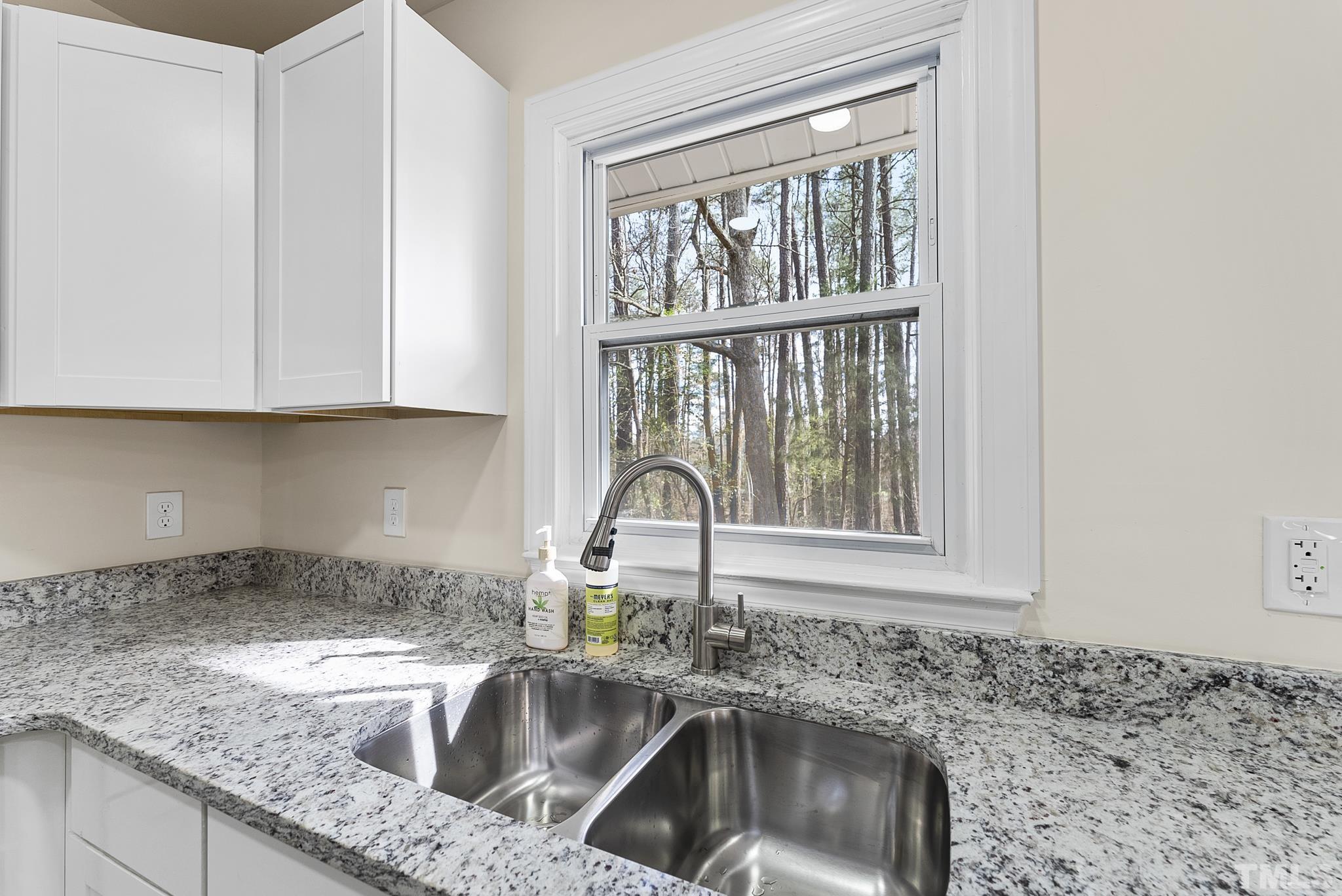 2125 Strebor Street Durham, NC 27705 - Photo 6 of 38 a kitchen with granite countertop a sink a window and cabinets