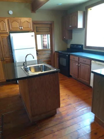 a kitchen with granite countertop a sink and a wooden cabinets