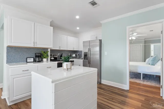 a kitchen with stainless steel appliances a refrigerator sink and white cabinets