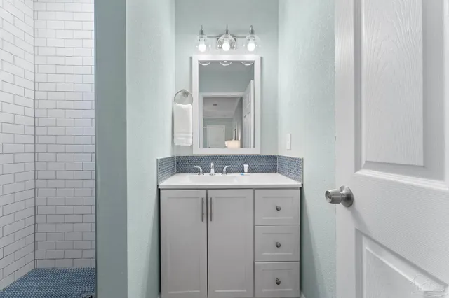 a bathroom with a granite countertop sink and a mirror
