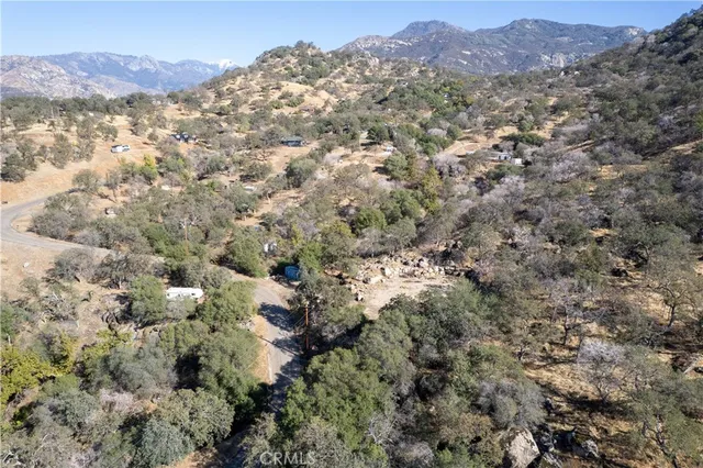 a view of a dry field with mountains in the background