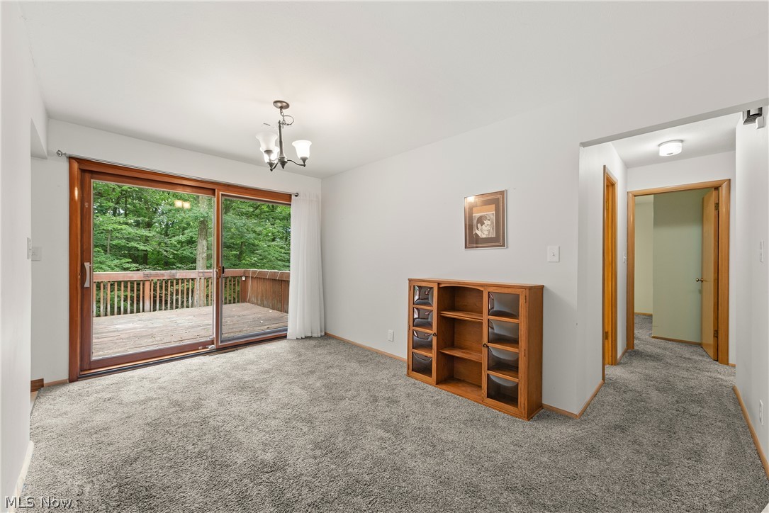 Carpeted spare room with a chandelier