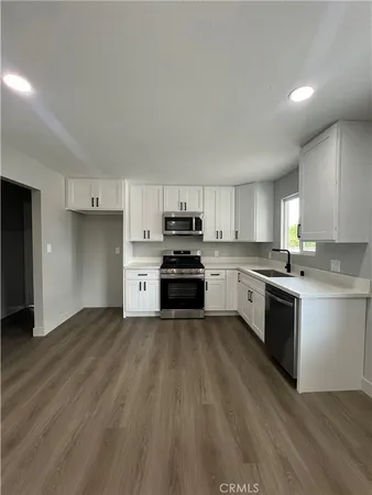 a kitchen with granite countertop a stove top oven and cabinets