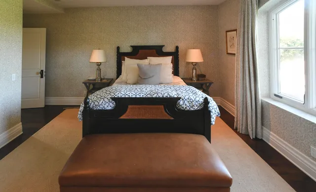 a large bed sitting in a bedroom next to a window