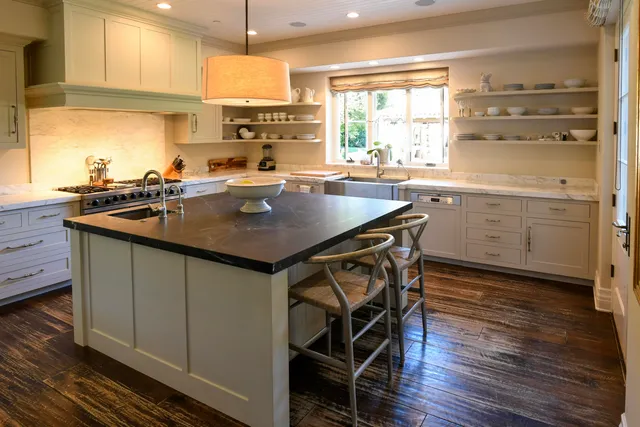 a kitchen with a table chairs sink and cabinets