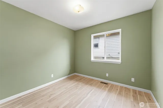 a view of a room with wooden floor and a bathroom