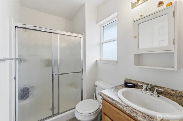 a bathroom with a granite countertop sink toilet and shower