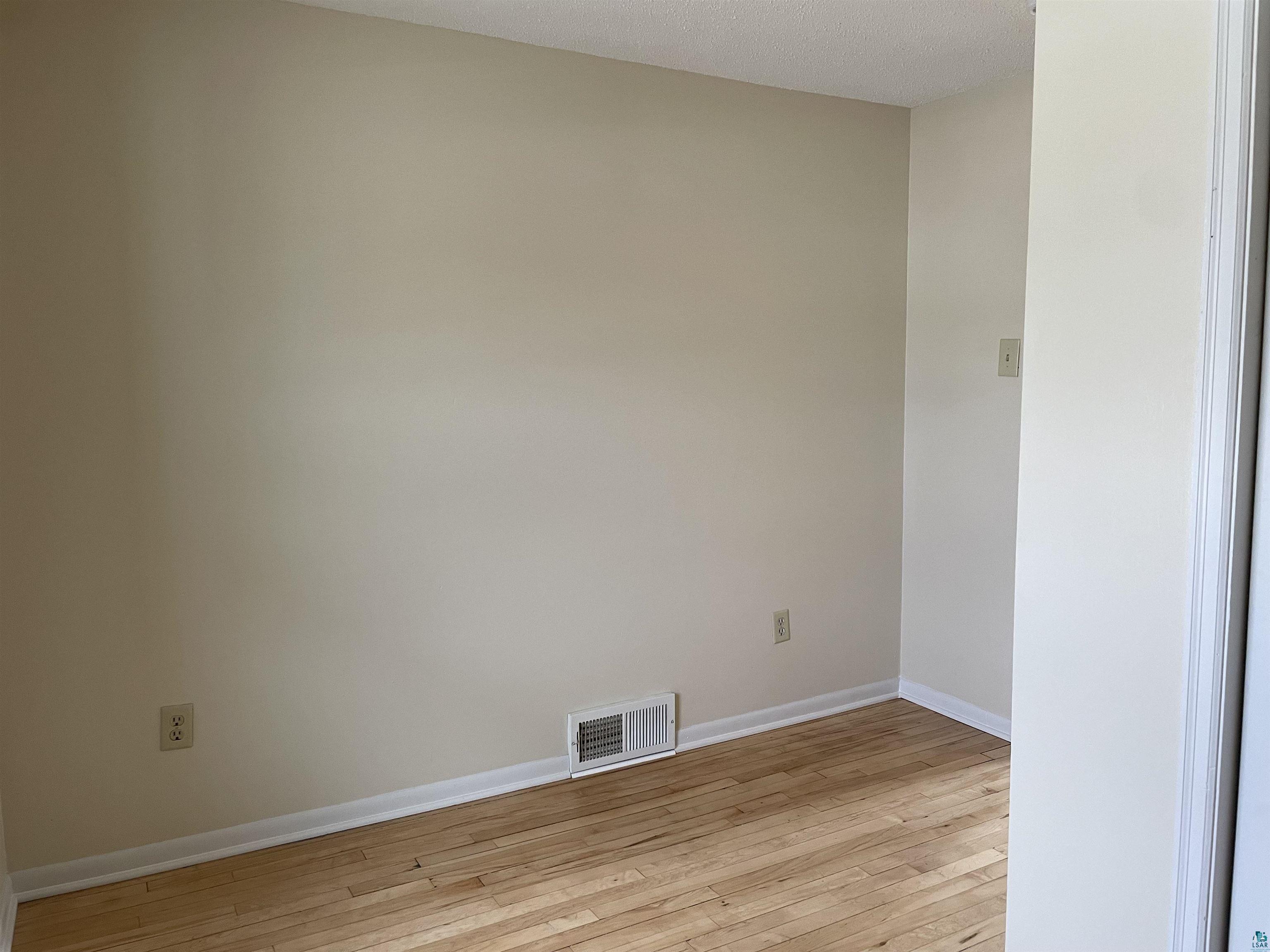 219 4th Street Proctor, MN 55810 - Photo 18 of 25 Empty room featuring light hardwood / wood-style floors and a textured ceiling