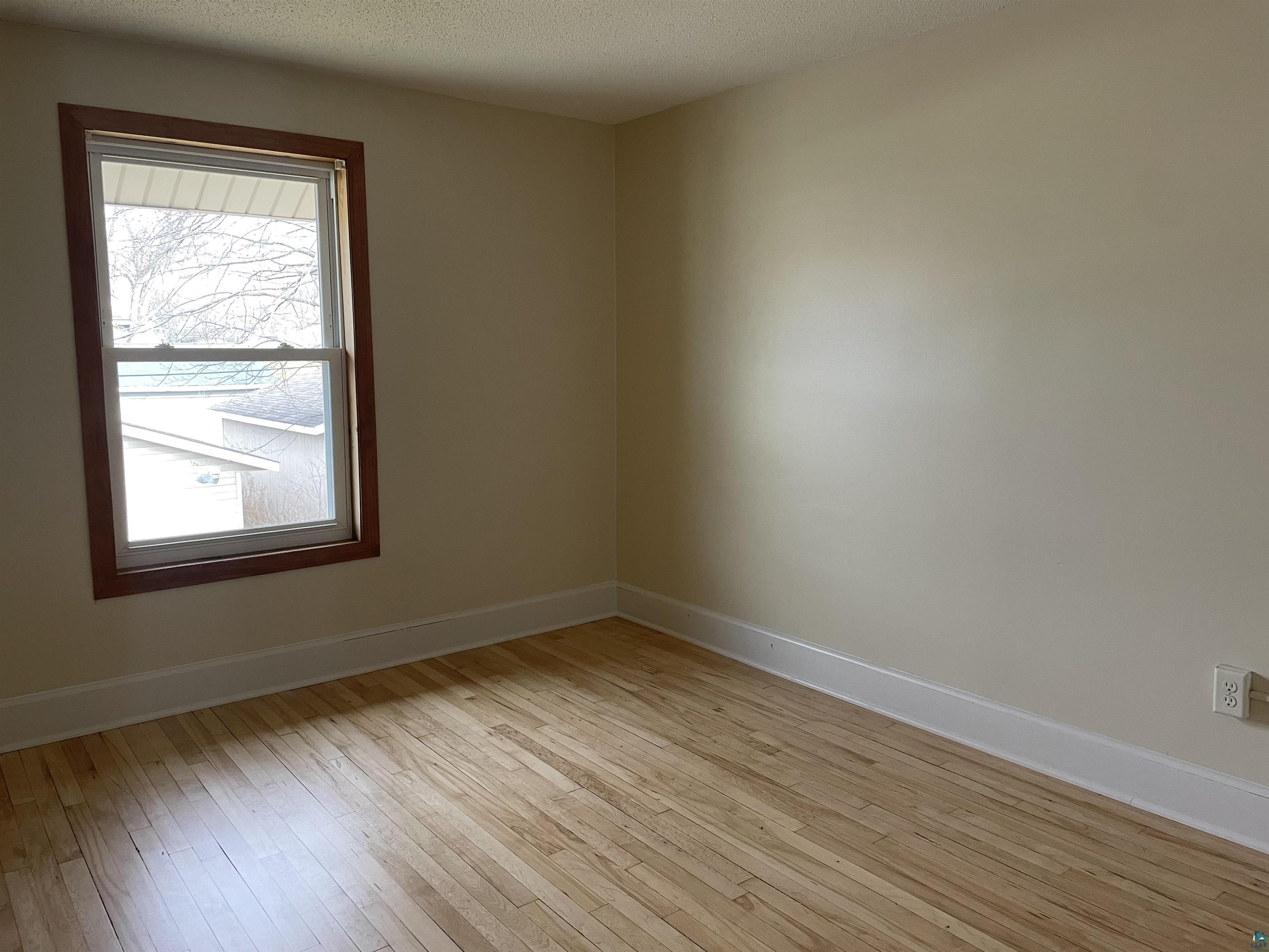 219 4th Street Proctor, MN 55810 - Photo 21 of 25 Unfurnished room with a textured ceiling and light wood-type flooring