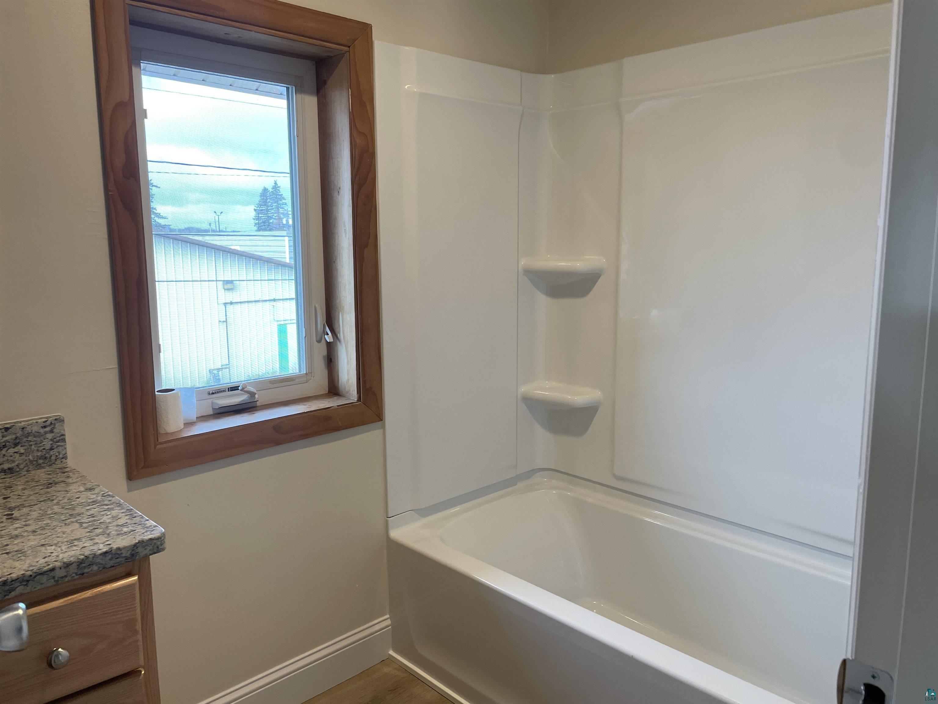 219 4th Street Proctor, MN 55810 - Photo 23 of 25 Bathroom featuring vanity and tub / shower combination