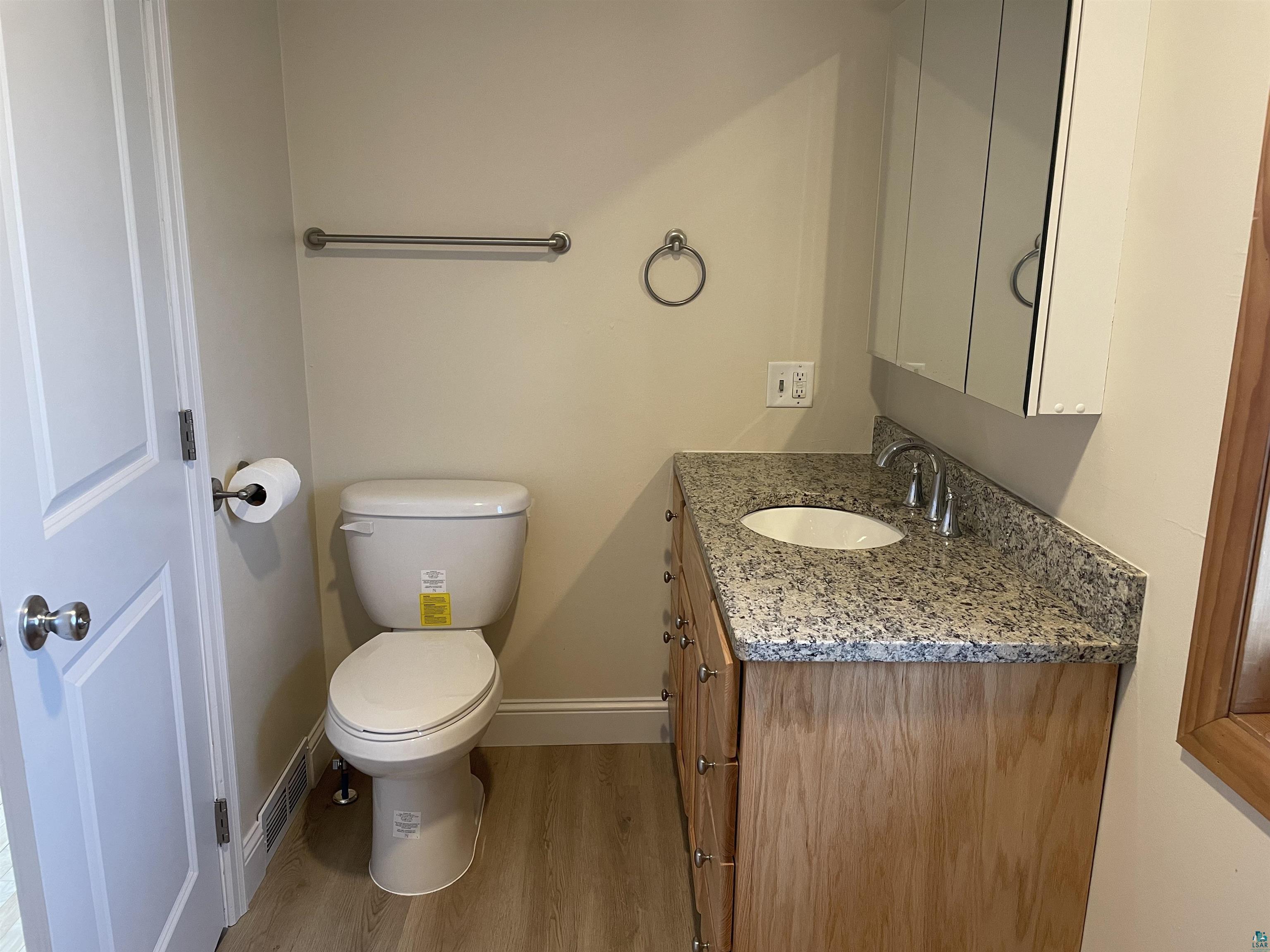 219 4th Street Proctor, MN 55810 - Photo 24 of 25 Bathroom with wood-type flooring, vanity, and toilet