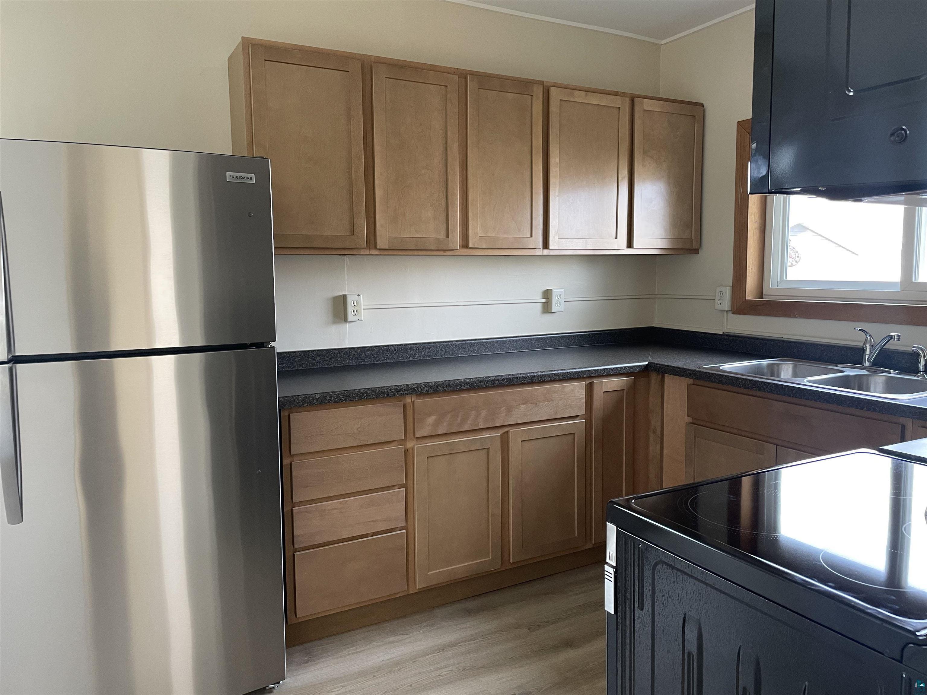219 4th Street Proctor, MN 55810 - Photo 9 of 25 Kitchen with stainless steel fridge, range, sink, and light hardwood / wood-style flooring