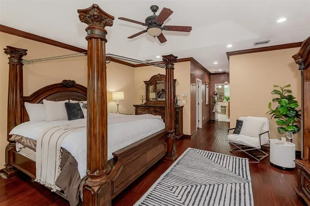 a bedroom with a large bed a chandelier and windows