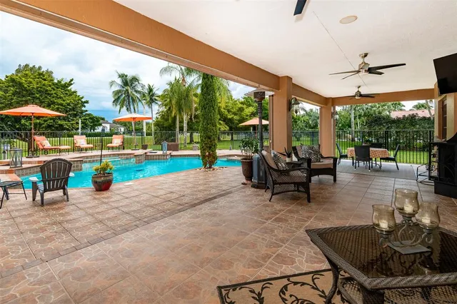 a view of a backyard with swimming pool and sitting area