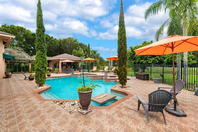 a view of a swimming pool with chairs in patio