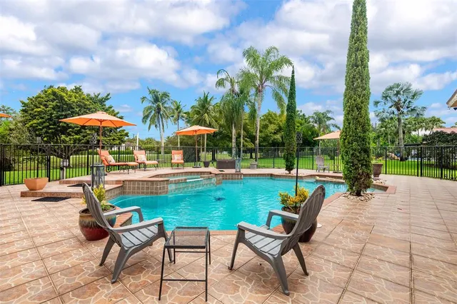 a view of a patio with dining table and chairs with a small yard
