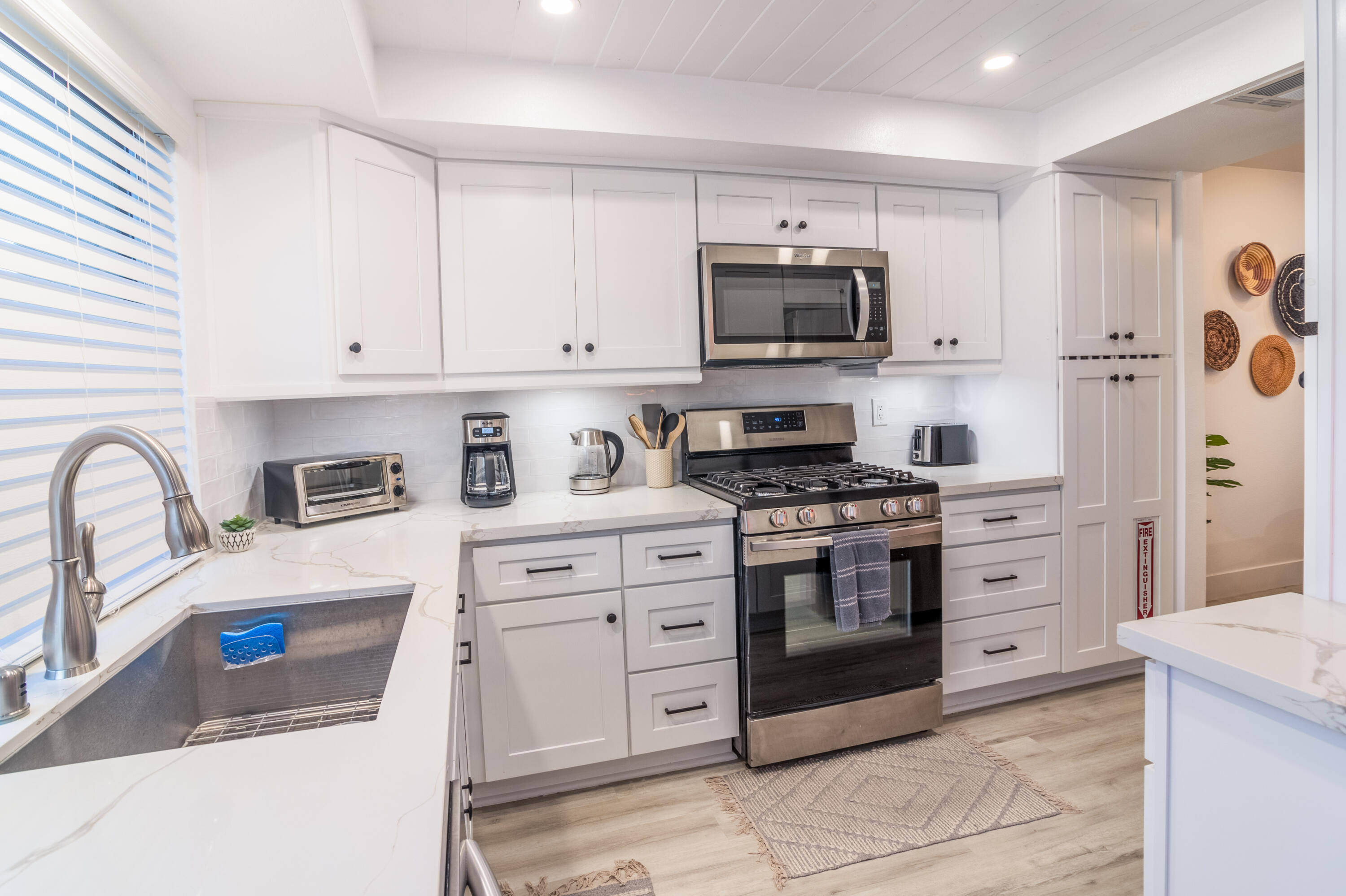 2415 Los Patos Drive Palm Springs, CA 92264 - Photo 4 of 17 a kitchen with stainless steel appliances granite countertop grey cabinets a stove a sink and dishwasher