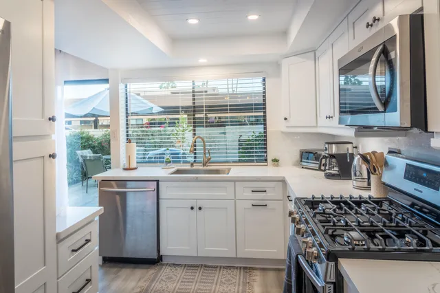 a kitchen with stainless steel appliances a stove a sink and a refrigerator