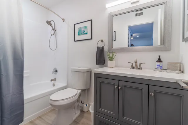 a bathroom with a granite countertop toilet sink and mirror